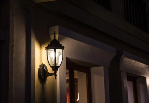 The wall lamp is on fire at night. Stock Photos