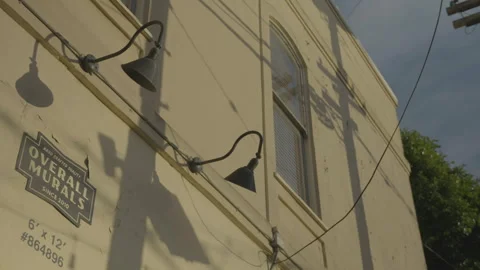 Wall lamps on building with soft sunlight and pole shadows, San Francisco Stock Footage 333580695