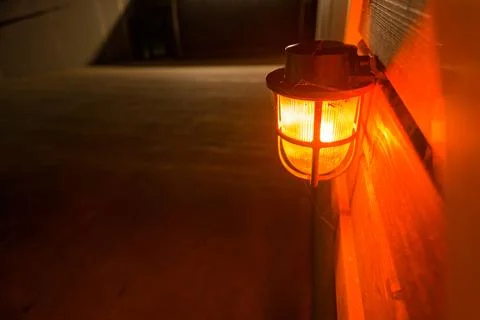 Wall lantern glowing warm orange light on Sylt island Stock Photos