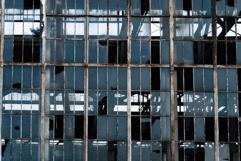 Wall with large broken windows in abandoned ruined factory building, broken Fotos de archivo