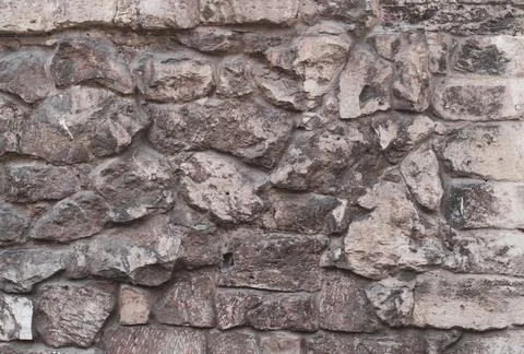 Wall with large stone, textured background close-up. Granite stones with moss Stock Photos