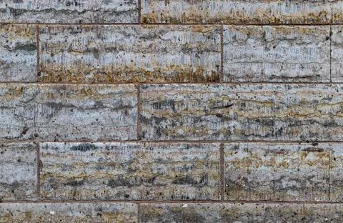 A wall of limestone blocks covered with dirt abstract background. Stock Photos
