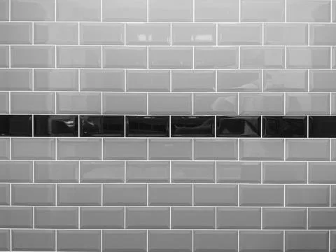 Wall lined with gray glossy ceramic tiles with dark line in the center. Foto stock