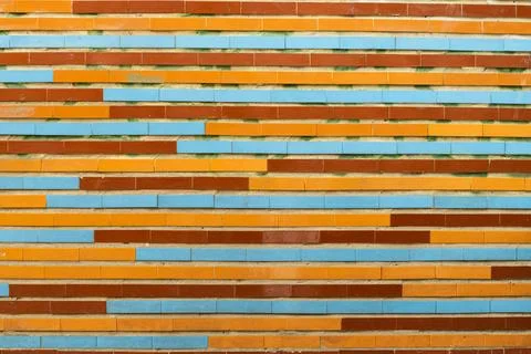 The wall is lined with a multi-colored pattern of oblong ceramic tiles Stock Photos