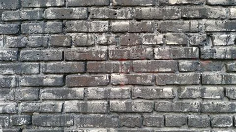 The wall is made of black brick. Background. Close-up. Stock Photos