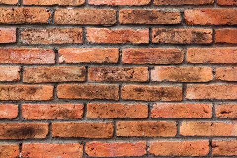 A wall made of bricks, its surface looks rough Stock Photos