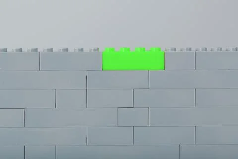 A wall made of children's construction kit parts with bright green bricks. 스톡 사진