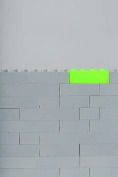 A wall made of children's construction kit parts with bright green bricks. 스톡 사진