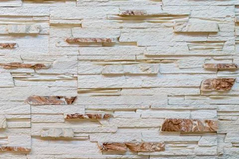 Wall made of decorative light brown stone. Decorating for the fireplace 스톡 사진