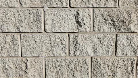 The wall is made of decorative rectangular gray stone. Stone background Stock Photos