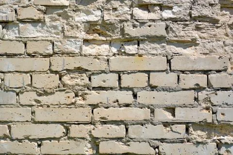 The wall is made of gray bricks with strong potholes.	 Stock Photos