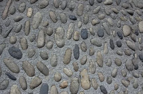The wall is made of oval cobblestones of different sizes.Texture or background. Stock Photos