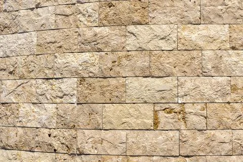 The wall is made up of rectangular stone pieces in varying shades of beige, e 스톡 사진