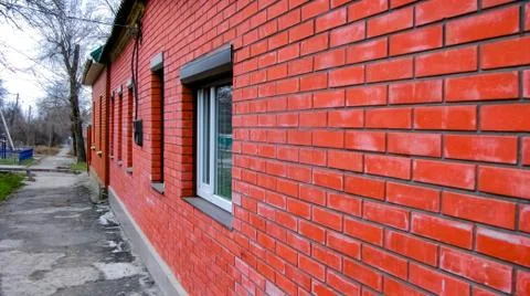 Wall made of the red brick with windows  of modern private dwelling house Stock Photos