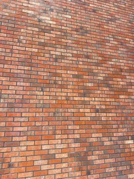 Wall made of red bricks showing different shades and textures in sunlight Stock Photos
