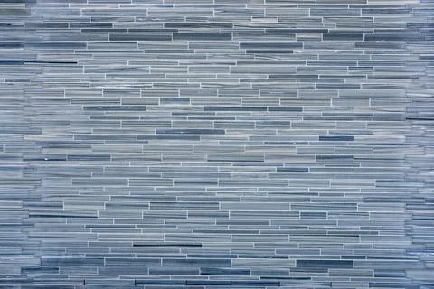 Wall made of small gray stone tiles 库存照片