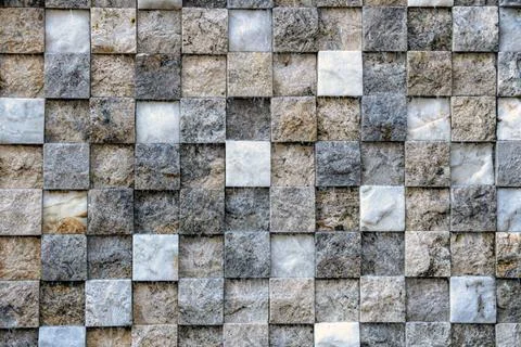 Wall made up of small square tiles arranged in a grid pattern. Stock Photos