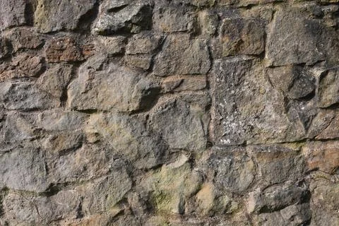 A wall made of stone with a rough texture Stock Photos