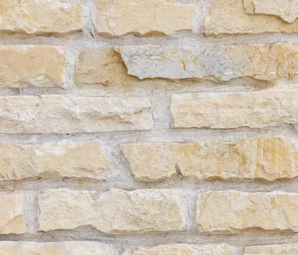 A wall made of tan bricks with a white border Stock Photos