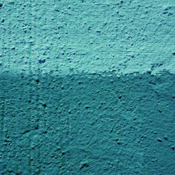 The wall is made of two-tone plaster in turquoise and blue-green colors. Stock Photos