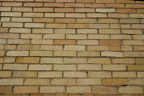 A wall made of yellow brick, capable of serving as a background. Foto stock