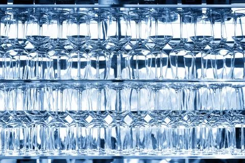Wall of many empty transparent wine glasses on glass shelf at bar cafe Stock Photos