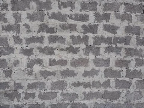 Wall with masonry of gray foam block with seams thickly smeared with cement Stock Photos