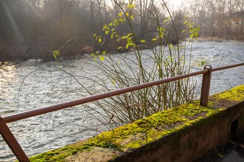 Wall with moss and a railing to a river in winter Stock Photos