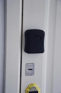A wall-mounted black key lock box with a combination lock. A modern securit.. Фото