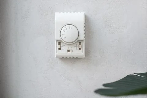 Wall-mounted climate control panel, air conditioner control panel on white wall Stock Photos