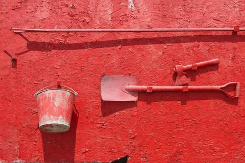 Wall-mounted fire shield with fire-fighting tools. Shovel, hook , axe,  bucke Stock Photos
