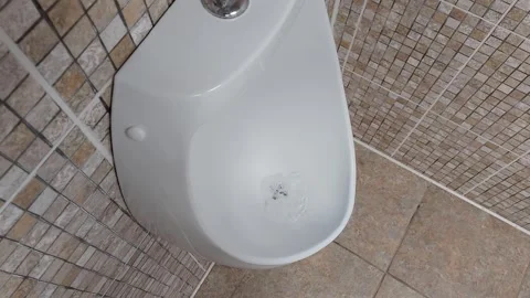 Wall-mounted mens urinal in a public toilet. The concept of cleanliness and 動画素材 300340458