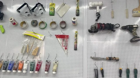 Wall mounted pegboard organizing various workshop tools Video stock 339067841