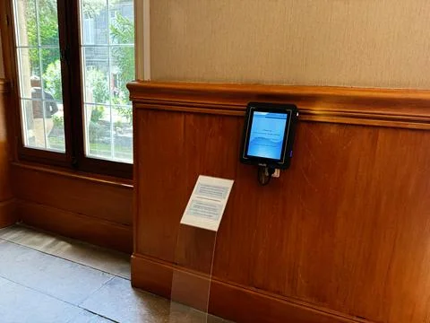 Wall mounted touchscreen tablet information display on wood paneling in Par.. Stock Photos