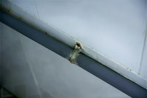 Wall-mounted water pipe bracket showing signs of rust and corrosion Stock Photos