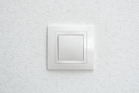 Wall mounted white light switch on white wall Stock Photos