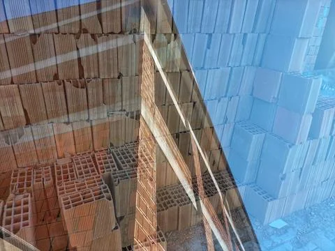 Wall of the new constructing building with bricks storage pallet on double .. 스톡 사진