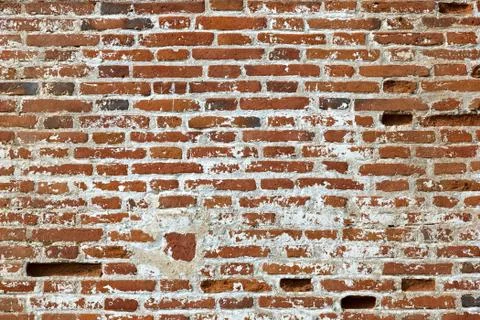 Wall of old red brick with remains of light-coloured plaster. Stock Photos