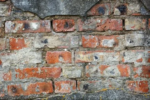 Wall of old red brick with remains of light-coloured plaster. Stock Photos