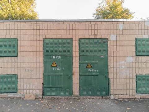 Wall of an old Soviet step-down electrical substation with a green door. Stock-Fotos