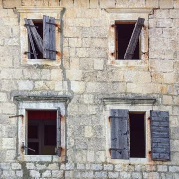 Wall with opened windows of old ruined house Stock Photos