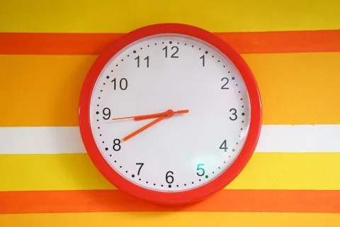 Wall orange clock on colorful Stock Photos