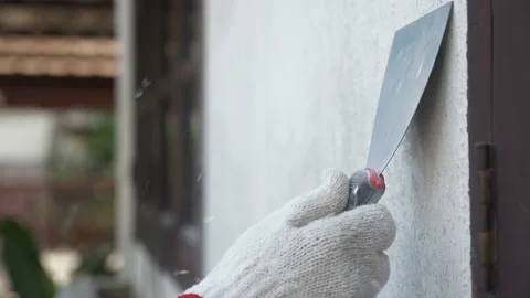 Wall painter using trowel peeling off old paint Stock Footage 212869202