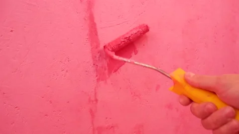 Wall painting pink paint roller Stock Footage