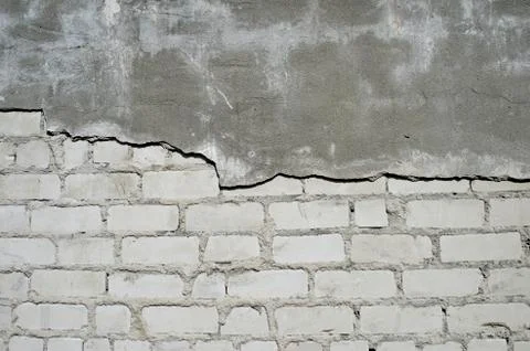 Wall with partially removed plaster in the form of figured drawing of a brick Stock Photos