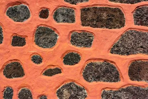 A wall with a pattern of rocks and a red substance Stock Photos