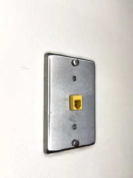 Wall plate with a yellow network jack installed in a room in a building for.. Stock Photos