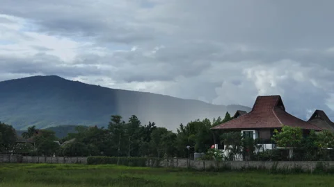 A wall of rain and a storm is approaching the village from the mountain, day Stock Footage 201060225