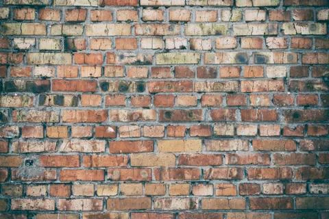 Wall of red brick with a layer of gray cement Stock Photos