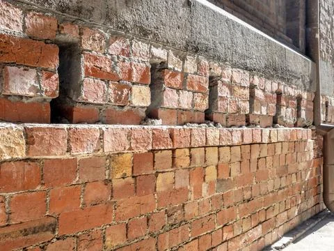 Wall of red bricks with cement and concrete structures Stock Photos